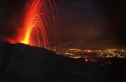 Eruptive activity at the intracrater cone on August 5, 1997. Lights of the urban center on the Eastern flank of Etna can be seen to the right. Photo by Boris Behncke.