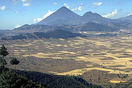 Here is a classically-formed strato volcano called Santa Maria, in Guatemala. Santa Maria had a huge eruption in 1902, from a vent on the other side of the cone as viewed from this direction. The big 1902 eruption was not from the summit. Starting in 1929, a lava dome began to grow in the 1902 crater, and it is still active today. It is named Santiaguito. The relatively large city of Quetzaltenango is out of view to the right.