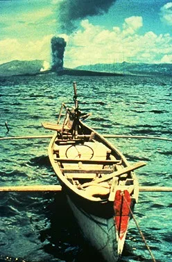 Fishing boat in the foreground with a plume of smoke rising in the back