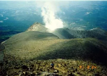 Looking down from Tokachi's summit with smoke billowing from a smaller volcano