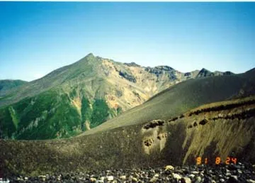 One of Tokachi's craters with a large volcano in the distance