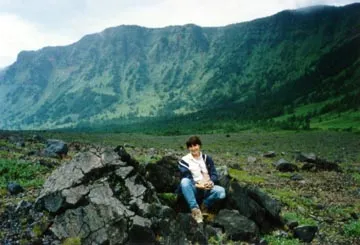 Intrepid volcano explorer sitting on a breadcrust bomb in Asama's caldera.